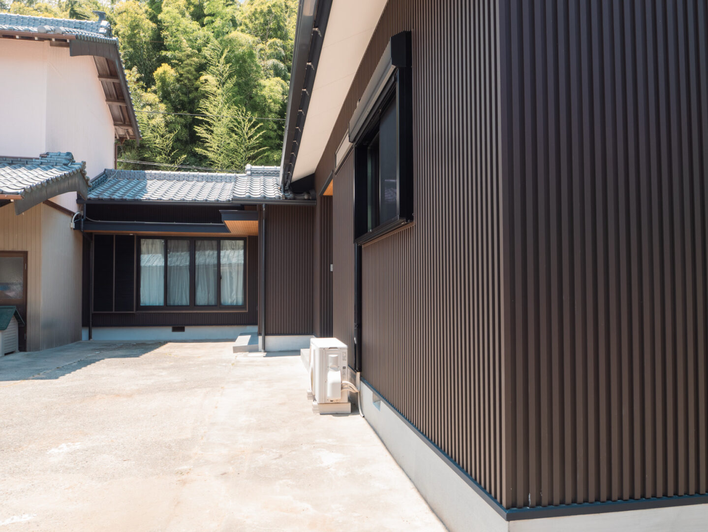 濃い茶色の外壁が印象的な平屋の庭